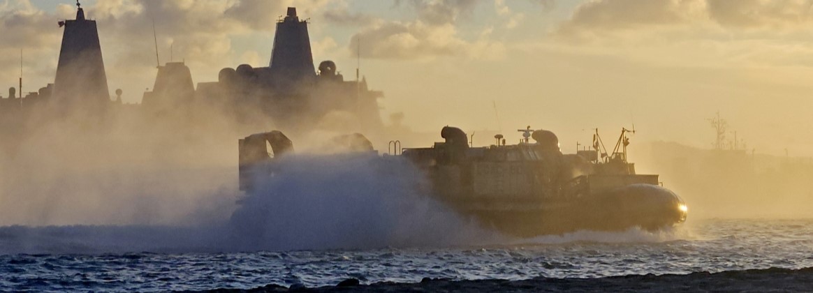  A landing craft air cushioned (LCAC), assigned to Naval Beach Unit (NBU) 7, transits past the amphibious transport dock ship USS Green Bay (LPD 20) while heading towards the beach at White Beach Nava
